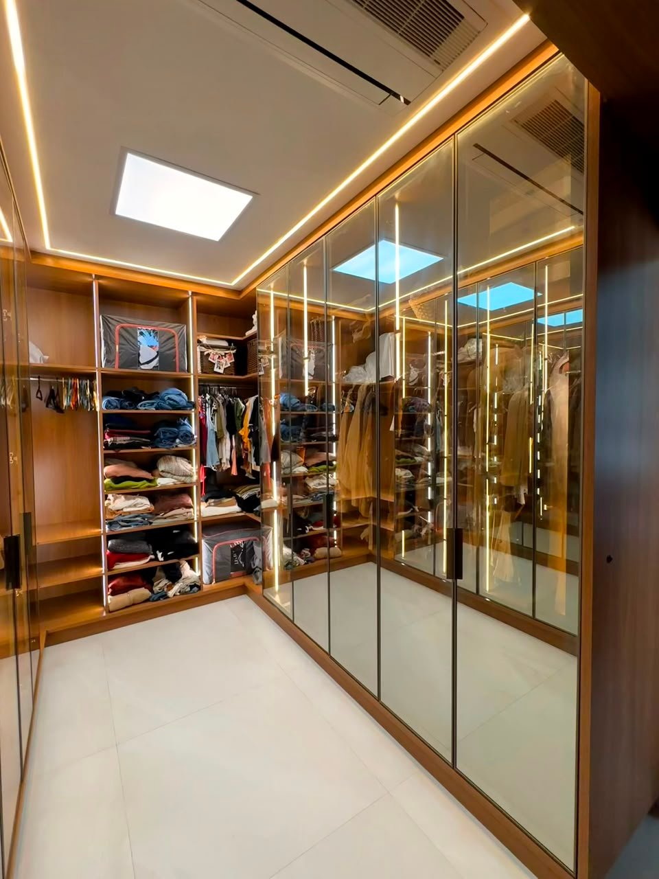 Closet planejado com portas espelhadas e iluminação em LED